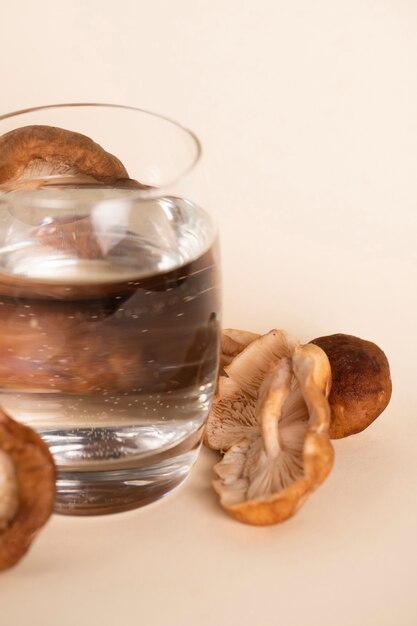 Arrangement with water in glass and mushrooms