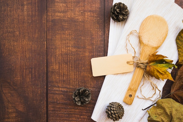 Free photo arrangement with wooden spoon and pine cones