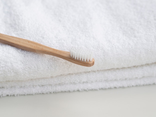 Arrangement with wooden toothbrush and towels