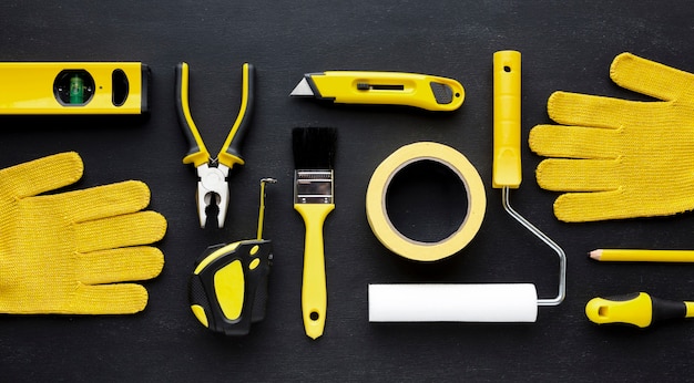 Free photo arrangement of yellow repair kit and construction gloves