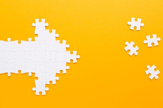 arrow made of puzzle pieces pointing to other pieces