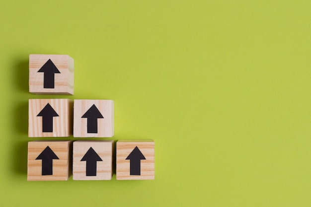 Free photo arrows on wooden cubes creating stairs