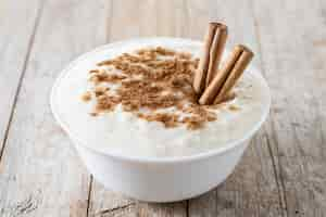 Бесплатное фото arroz con leche рисовый пудинг с корицей в миске на деревянном столе