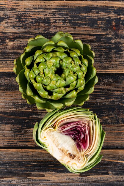 Artichoke and slice with top view on a dark wooden 