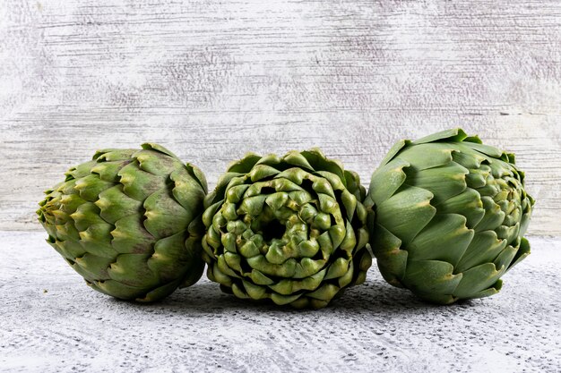 Artichokes on a light gray . side view. space for text