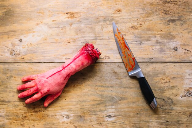 Artificial cut hand in blood and knife