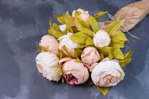 Artificial flower bouquet on blue.