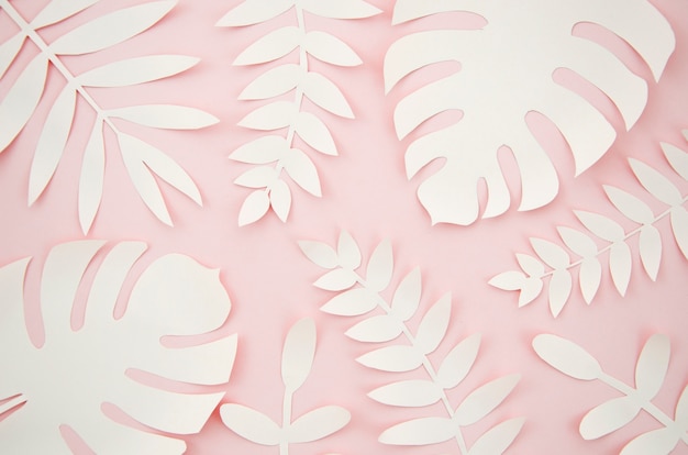 Бесплатное фото Искусственные листья в виде бумаги с розовым фоном
