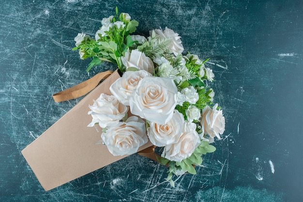 Foto gratuita fiore bianco artificiale in un pacchetto, sullo sfondo blu.