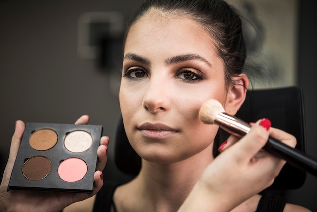 Artist applying blush on model