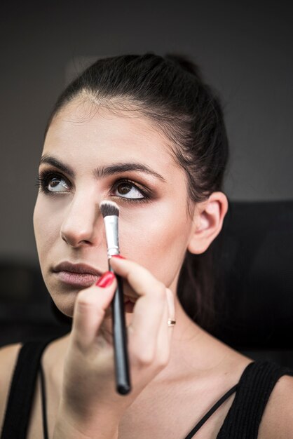 Artist applying make up on model