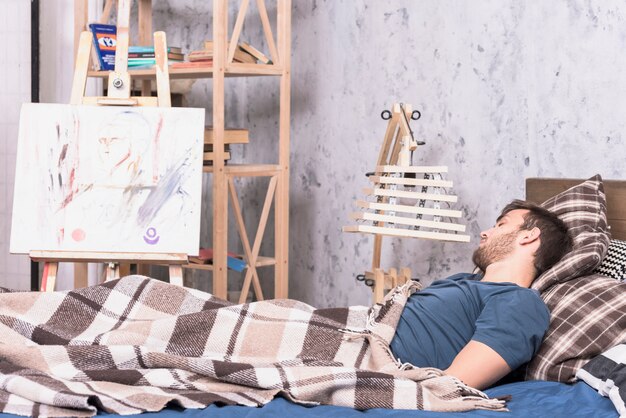 Artist in bed in studio