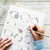 Бесплатное фото Художник рисует каракули цветочные венки на бумаге