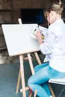 Free photo artist in front of blank canvas