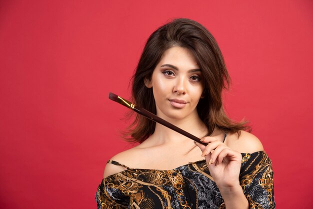 Artist girl posing with her painting brush. 