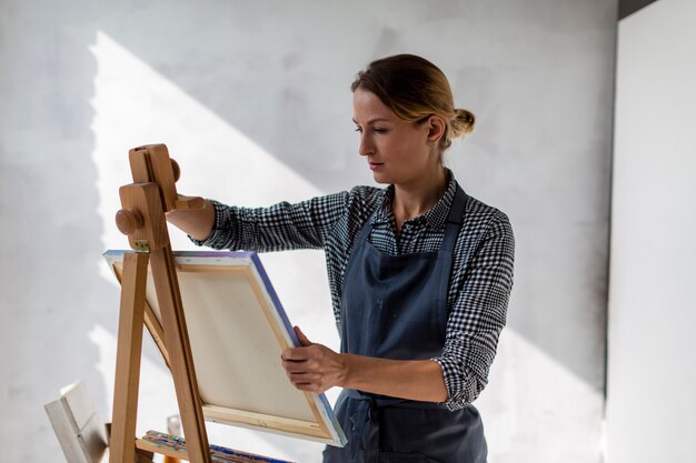 Artist holding canvas in studio