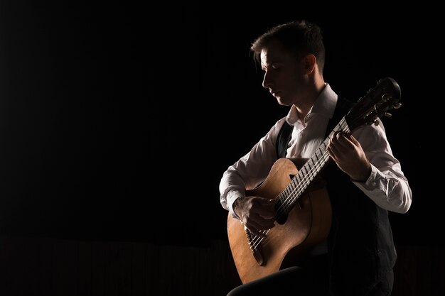 Artist man on stage playing the guitar copy space