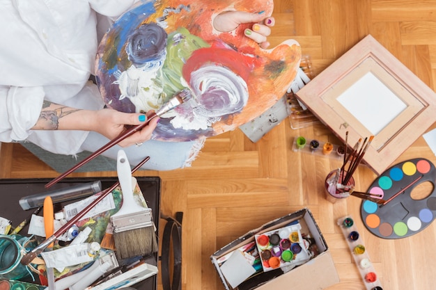 Artist mixing dye on palette