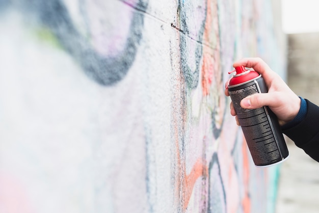 Foto gratuita graffiti della pittura dell'artista con la latta di spruzzo