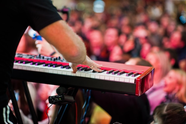 Foto gratuita l'artista suona al pianoforte audio sul palco di una sala da concerto dietro i popoli