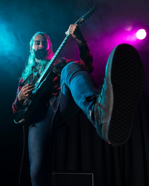 Artist playing guitar low view