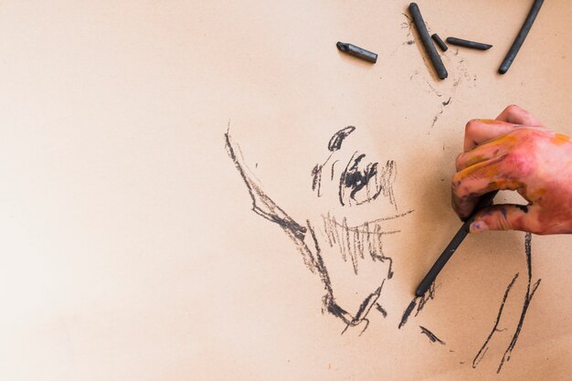 紙の上の木炭で描くアーティストの手スケッチ