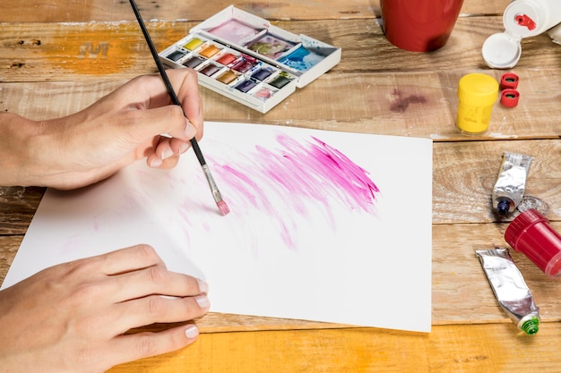 Artist using paint brush on paper