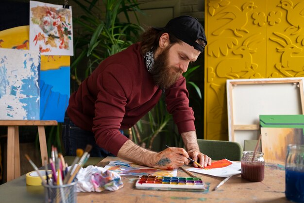 Artist using watercolor to paint his art in the studio