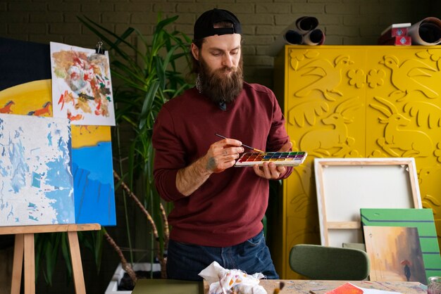 artist using watercolor to paint his art in the studio
