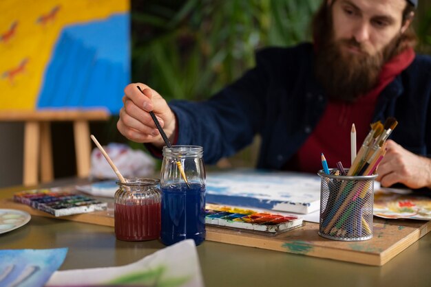 Artist using watercolor to paint his art in the studio