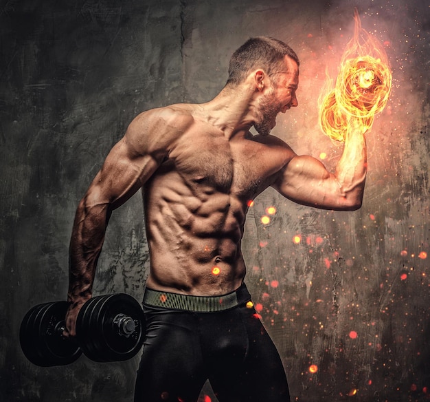 Free photo artistic portrait of shirtless muscular male with burning dumbbell.