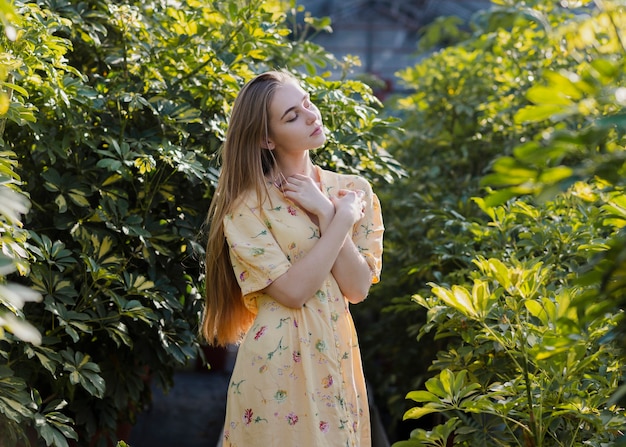 Artistic shot of a posing woman in a greenhouse