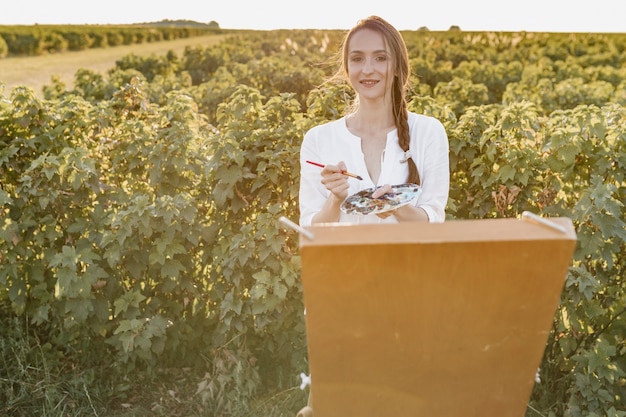 Free photo artistic woman painting in the nature