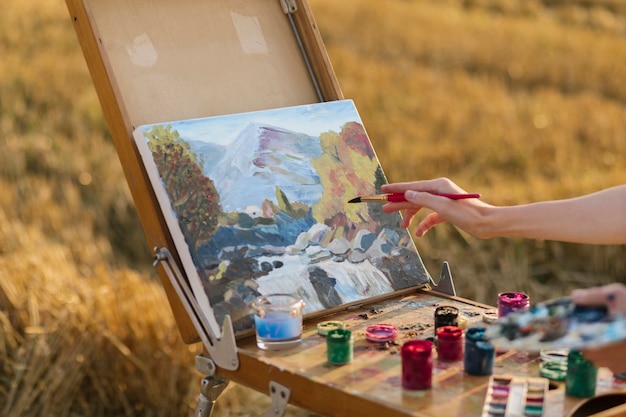Artistic woman painting in the nature