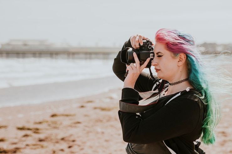 Free Photo artsy woman taking a photo at a beach