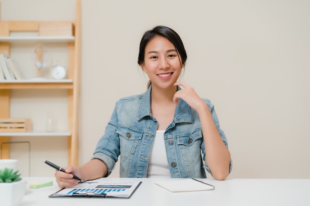 Asia business woman feeling happy smiling and looking to camera while relax at home office. 