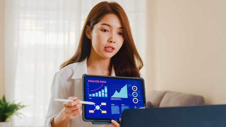 免費 Photo 亞洲女商人使用筆記型電腦和平板電腦向同事介紹計劃,在客廳在家工作時進行視頻通話.自我隔離,社交距離,冠狀病毒隔離.
