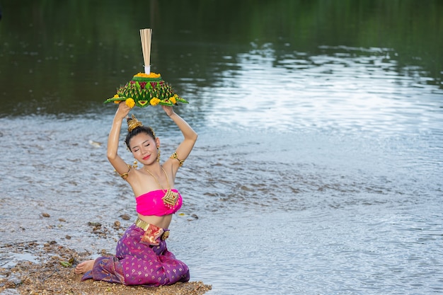 Азиатская женщина в тайском традиционном владении kratong. фестиваль лой кратонг