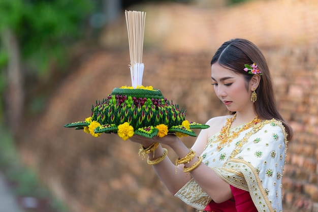 Foto gratuita asia donna in abito tailandese tradizionale attesa kratong loy krathong festival