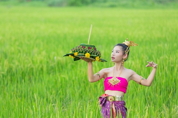 Азиатская женщина в тайском традиционном владении kratong. Фестиваль лой кратонг