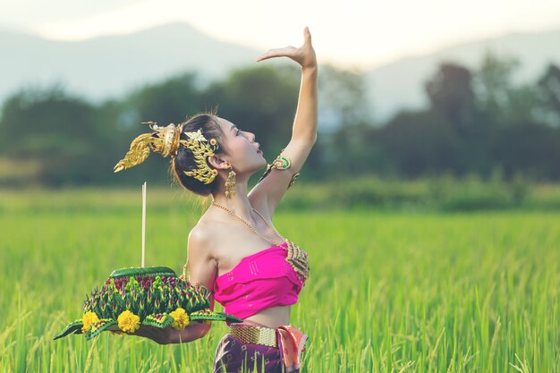 Азиатская женщина в тайском традиционном владении kratong. Фестиваль лой кратонг