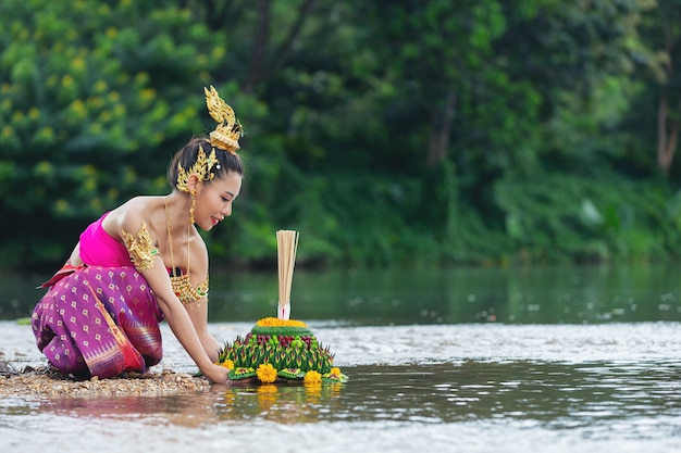 Азиатская женщина в тайском традиционном владении kratong. Фестиваль лой кратонг