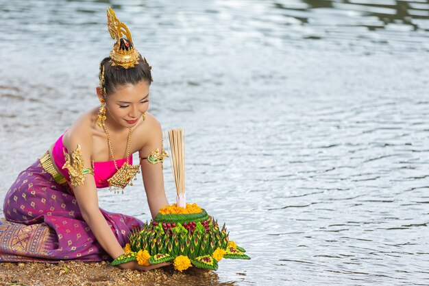 Азиатская женщина в тайском традиционном владении kratong. Фестиваль лой кратонг