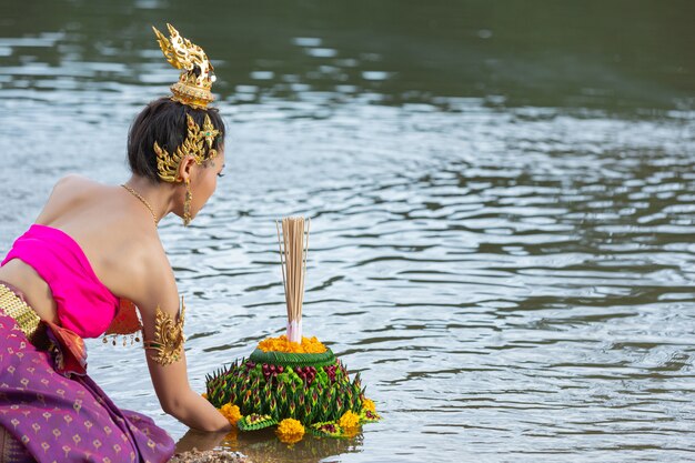 Азиатская женщина в тайском традиционном владении kratong. Фестиваль лой кратонг