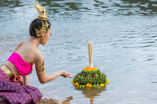 Азиатская женщина в тайском традиционном владении kratong. Фестиваль лой кратонг