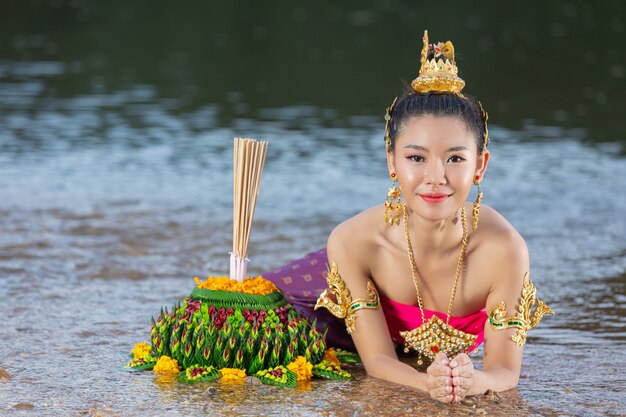 Азиатская женщина в тайском традиционном владении kratong. Фестиваль лой кратонг