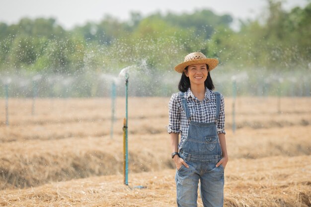 Asia young female farmer in hat standing and walk in field woman  to inspecting in agricultural garden. Plant growth. Concept ecology, transport, clean air, food, bio product.