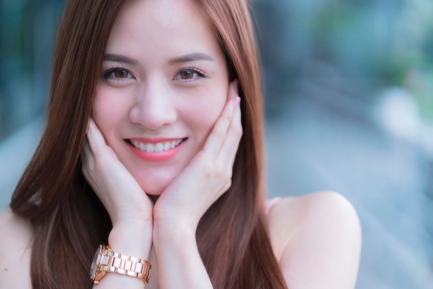 アジアの美しい女性の長い髪のファッションの肖像画ピンクのドレスは幸せで陽気な笑顔