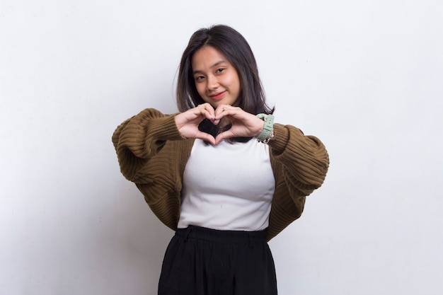 흰색 배경에 고립 된 심장 기호 사랑을 보여주는 아시아 아름 다운 젊은 여자