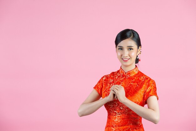 中国の旧正月にお祝いのジェスチャーを持つアジアの美しさの女性